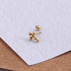 Macro detail of golden stainless steel cross stud earring with ball screw back design