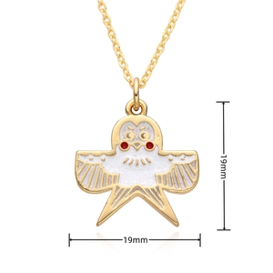Detail view of a gold owl necklace with white enamel inlay and 19mm x 19mm dimensions