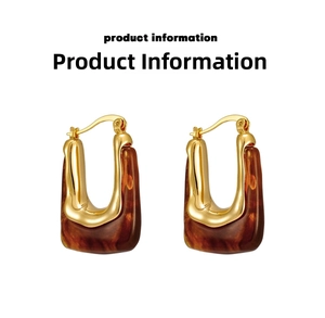 Detail view of U-shaped earrings featuring gold metal and brown tortoiseshell resin texture