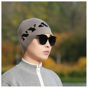 Detail of dark grey knit beanie with black NY embroidery and thick texture for winter