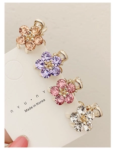 Close-up of four mini crystal flower hair claws in multiple colors on a display card