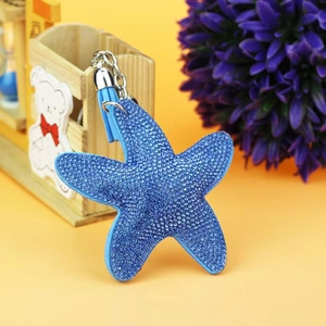 Detailed close-up of a blue starfish keychain with shiny rhinestones and a blue tassel
