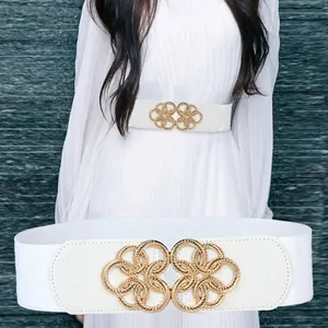 White elastic waist belt for women with golden floral buckle on a pleated dress