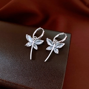 Detailed macro view of silver dragonfly hoop earrings with sparkling zircon gemstones