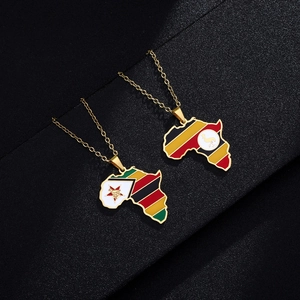 Macro detail of Zimbabwe and Uganda flag pendants on golden map necklaces