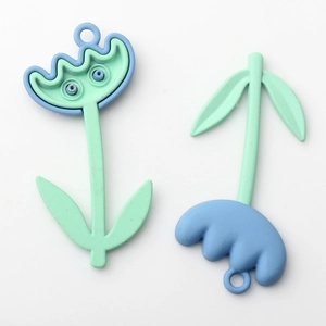 Close-up of blue and green tulip-shaped flower charms with matte finish for DIY jewelry