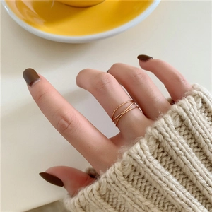 Detail shot of a three-layer intertwined rose gold ring worn on a finger