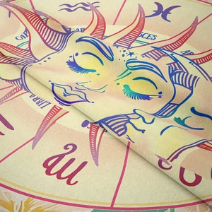 Detail of bohemian sun and moon tapestry fabric showing soft texture and zodiac print