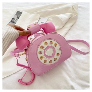Close-up of pink patent leather crossbody bag in a creative retro telephone design