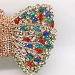 Close-up of multicolor crystals and bow design on elegant gold evening clutch