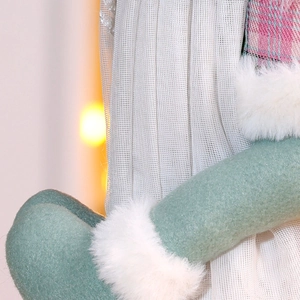 Macro view showing mint green felt, grey tulle skirt and plaid fabric on Christmas doll