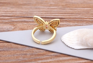 Detailed close-up of 18K gold butterfly open ring with colorful zircon and pink stone