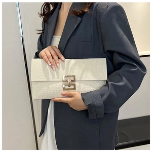 Detail of white crocodile texture felt clutch bag with a golden rectangular metal buckle