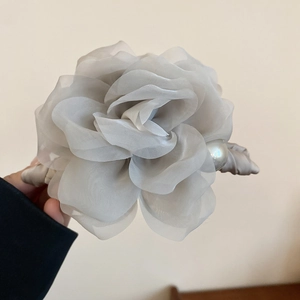 Détail de la rose en organza gris et de la perle blanche sur la pince à cheveux