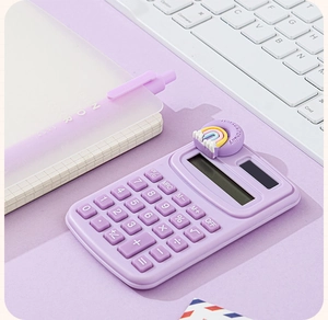 Mini purple electronic calculator with a 3D rainbow charm on a pastel office desk