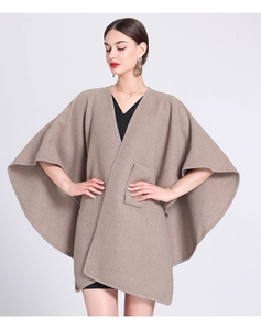 Detail view of khaki knit poncho cardigan with large pocket and loose batwing sleeves