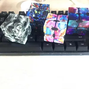 Detail view of four infinity cube stress relief toys on a surface showing various patterns
