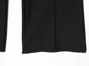 Gros plan détaillé de l'ourlet du pantalon noir avec couture plate et texture en maille