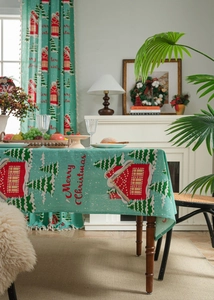 Detail of Christmas house and tree print on linen tablecloth with tassel fringe