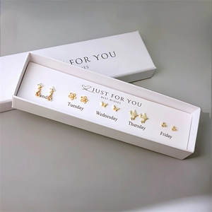Detailed set of five gold pearl stud earrings with Monday to Friday gift box labels