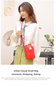 Close-up of red quilted phone bag with white rabbit buckle and thin leather strap