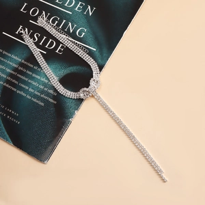 Macro view of silver rhinestone choker showing three-row tassel design and brilliant shine