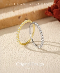 Close-up of gold and silver eternity bands with micro-pave crystals on matte display