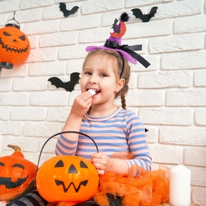 Detail of purple witch hat headband with orange sequins and black bow for Halloween