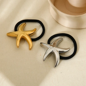 Elastici per capelli a forma di stella marina oro e argento su sfondo in tessuto