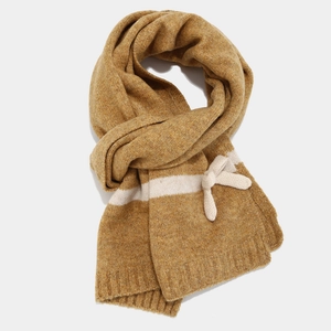 Detail of yellow knit scarf with white stripes and a 3D bow accent for winter warmth