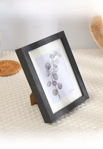 Black minimalist solid wood frame 5x7 inch with stand on a beige woven surface