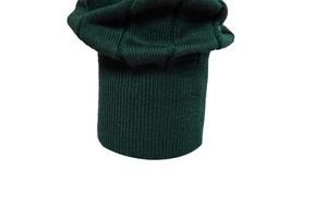 Dettaglio maglione in maglia verde scuro con polsini a costine e motivi a trama 3D