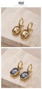 Detail view of champagne and grey rectangular crystal drops on gold hoop earrings