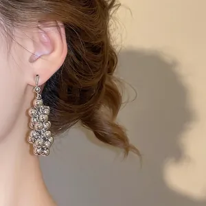 Boucles d'oreilles pendantes géométriques en argent avec perles portées par un mannequin
