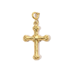 Macro view of a vintage gold-plated stainless steel cross pendant with embossed floral patterns