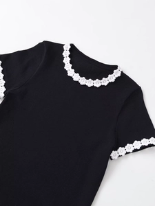 Detail of floral lace trim on neck and cuffs of black ribbed short sleeve T-shirt