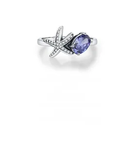 Macro shot of silver starfish ring featuring a purple oval stone and brilliant pavé diamonds