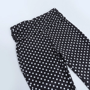 Détail du pantalon à pois à taille haute montrant la conception de la taille plissée