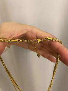 Detailed close-up of 18K gold-plated lobster clasp and adjustable extension on layered necklace