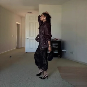 Women's burgundy leather jacket with black lace skirt in a trendy streetwear style