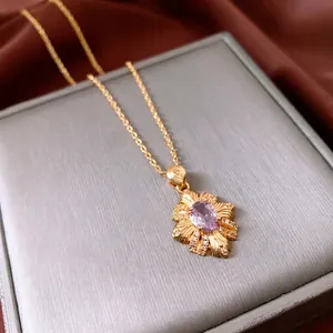 14k gold plated necklace with a radial petal pendant and oval purple gemstone center