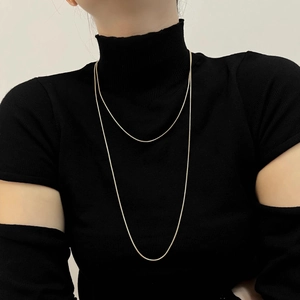 Detailed view of an 18K gold-plated double-layer snake chain necklace on a model
