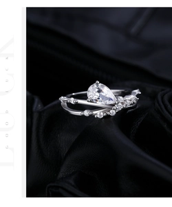 Macro shot of s925 silver ring featuring pear-shaped gemstone and intertwined diamond bands