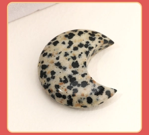 Detailed close-up of crescent moon natural stone ornament with polished black spots