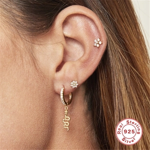 Close-up of 925 sterling silver snake pendant and flower studs on ear