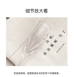 Close-up of high-transparency glass goblet on a magazine for modern dining table decor