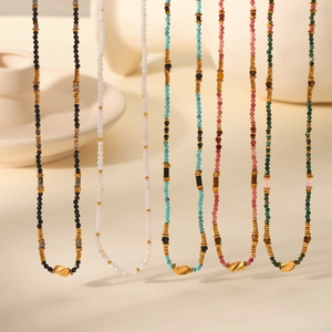 Detailed macro view of five colorful beaded necklaces with gold metal charms