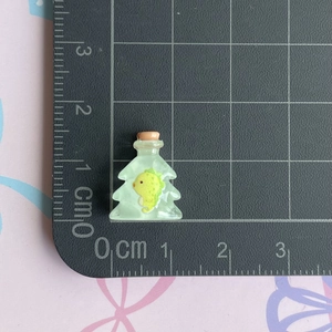 Mini resin wishing bottle with yellow duckling detail shown against a centimeter scale