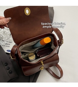 Macro shot of dark brown crossbody bag interior showing spacious compartments and zip pocket