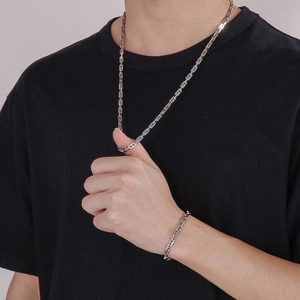 Male model wearing 5mm silver bamboo link chain necklace and bracelet set in street style